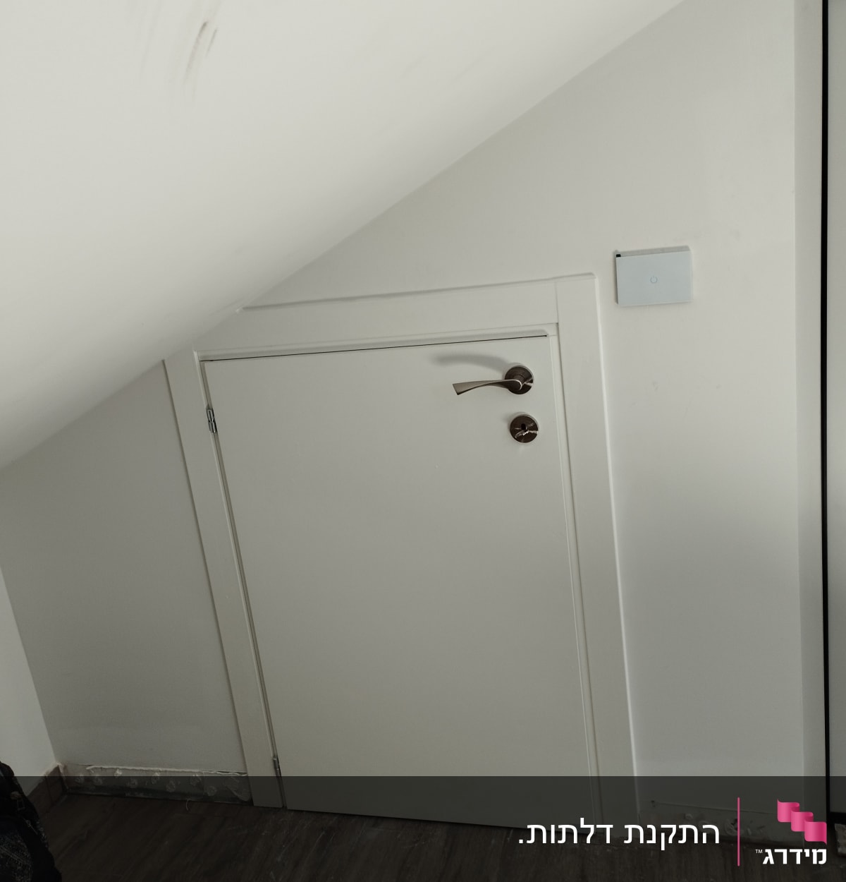 דלת קטנה עם ידית מתכת מתחת למדרגות